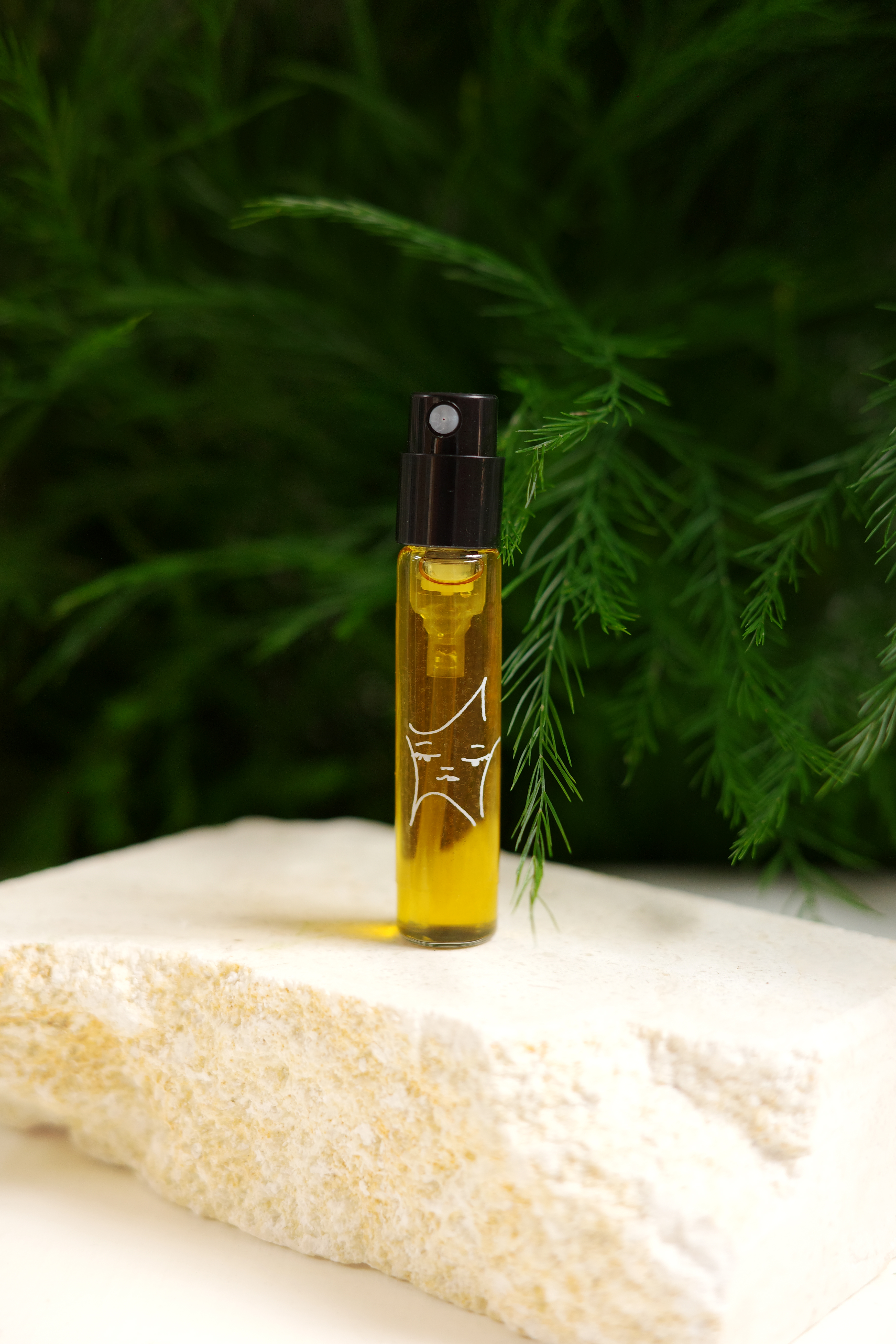 a product photo of the sample size, in a small atomizer with a black top and star girl sticker